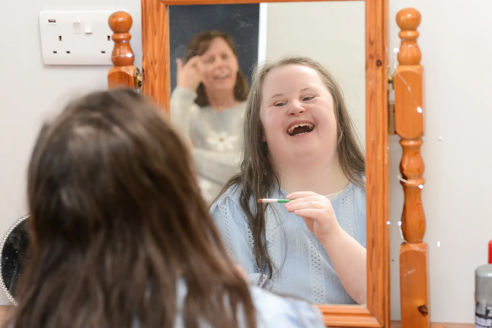 young girl laughing in the mirror